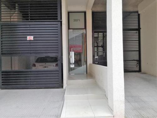 un edificio con garaje con un coche en la ventana en Apart del Centro 03, en Santa Fe