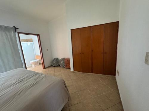 a bedroom with a bed and a wooden cabinet at Oasis de paz con alberca privada in Texcalpan