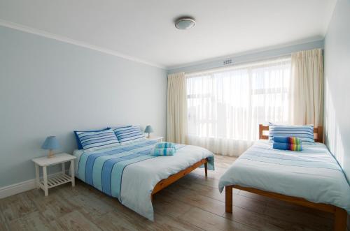 1 dormitorio con 2 camas y ventana en Tassies en Gansbaai