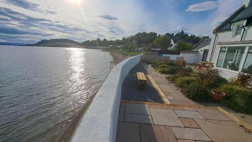 a retaining wall next to a body of water at SEASIDE HOUSE 12 Shore Street, Avoch IV9 8QD in Avoch