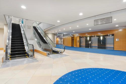 an empty lobby with escalators in a building at Embarc Vancouver in Vancouver