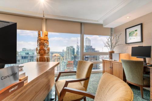 an office with a desk and chairs and a large window at Embarc Vancouver in Vancouver