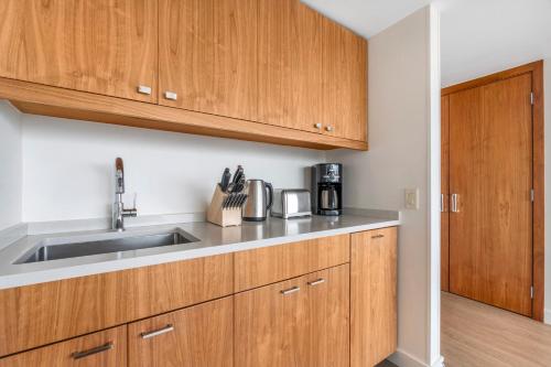 a kitchen with wooden cabinets and a sink at Embarc Vancouver in Vancouver
