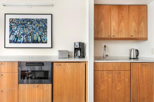a kitchen with wooden cabinets and a picture on the wall at Embarc Vancouver in Vancouver