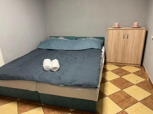 a bedroom with a bed with two white shoes on it at Lawendowa Przystań - Dolina Baryczy in Ujeździec Mały