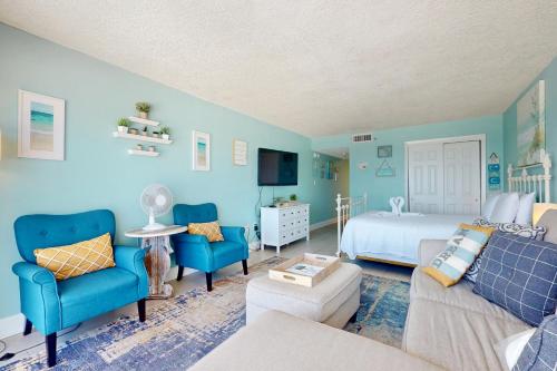 a blue bedroom with a bed and blue chairs at Islander W 703 in Fort Walton Beach
