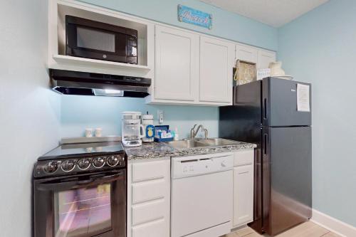 a kitchen with a stainless steel refrigerator and a microwave at Islander W 703 in Fort Walton Beach