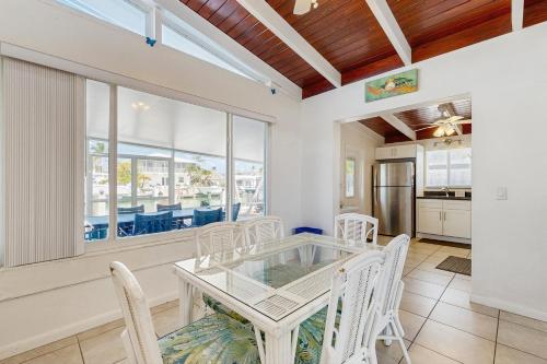 a dining room with a glass table and white chairs at Downhome Cabin by the Canal in Key Colony Beach