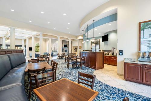 a restaurant with tables and chairs and a bar at Best Western PLUS Westgate Inn and Suites in Leland