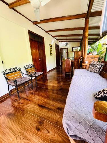a bedroom with a bed and chairs in a room at Colibri Ecolodge 3 minutes walk to beach and town in Puerto Viejo