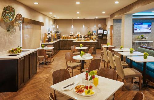 a restaurant with tables and chairs and a cafeteria at Best Western Plus Lewisville Flower Mound in Lewisville