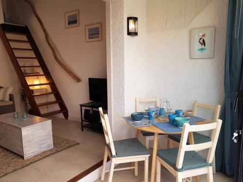 une salle à manger avec une table et deux chaises dans l'établissement Gruissan Ayguades maison de vacances L'Etang 4 personnes, à Gruissan