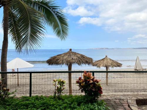 une vue sur une plage avec des parasols et l'océan dans l'établissement Bungalow Tranquilidad 2, à La Manzanilla