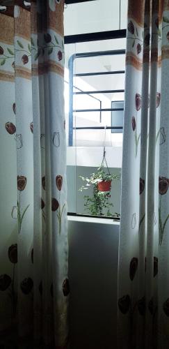 a room with a window with curtains with flowers on it at PATAWASI Guest House Cusco in Cusco