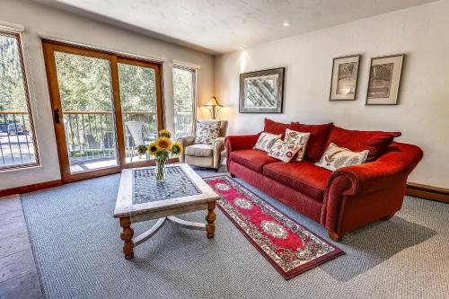 a living room with a red couch and a table at Spacious Top Floor Condo Aspen in Aspen