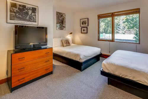 a bedroom with two beds and a flat screen tv at Spacious Top Floor Condo Aspen in Aspen