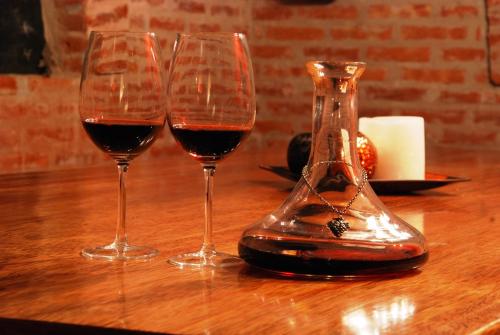 three wine glasses sitting on a wooden table at Miravida Soho Hotel & Wine Bar in Buenos Aires