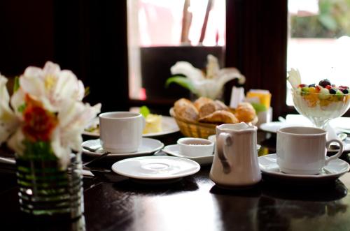 a table with cups and plates of food and bread at Miravida Soho Hotel & Wine Bar in Buenos Aires