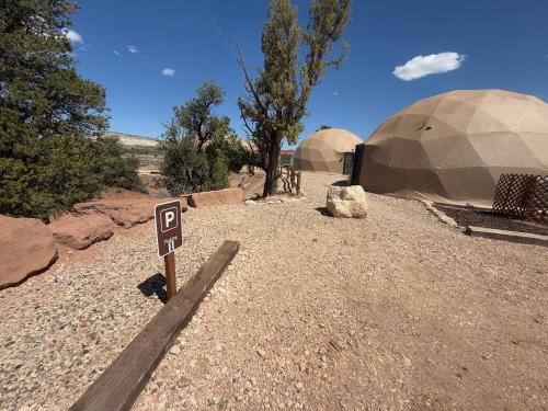 a sign in the middle of a desert with two domes at Bryce Glamp And Camp in Cannonville