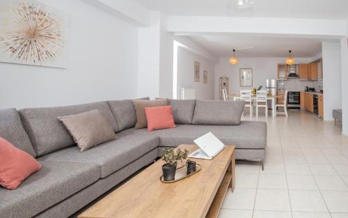 un salon avec un canapé gris et une table en bois dans l'établissement Phoenix Apartment, à Ierápetra