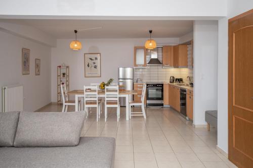 une cuisine et un salon avec une table et des chaises dans l'établissement Phoenix Apartment, à Ierápetra