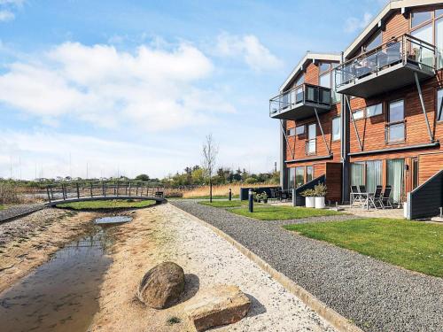 a house with a pond next to a building at 4 person holiday home in Bogense-By Traum in Bogense