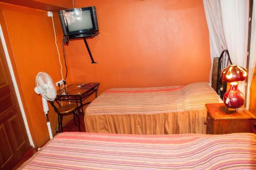 a hotel room with two beds and a tv at Khweza Bed and Breakfast in Nairobi