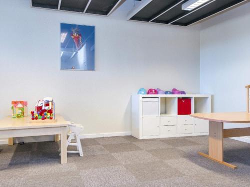 a childs room with a table and a crib at 6 person holiday home on a holiday park in Fanø in Fanø
