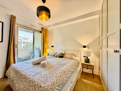une chambre avec un grand lit et une fenêtre dans l'établissement Splendide Appartement - Vue Mer - Cannes à 5 min, à Vallauris