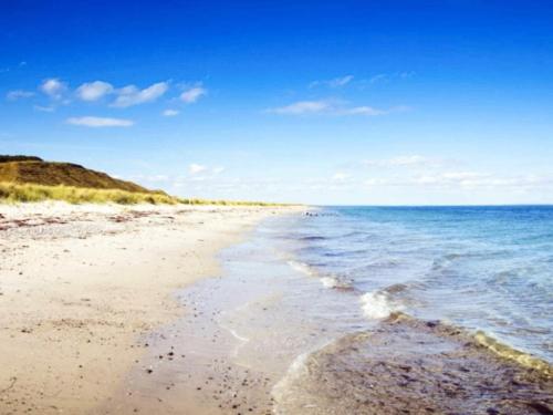 a sandy beach with the ocean in the background at 7 person holiday home in Løgstør-By Traum in Løgsted