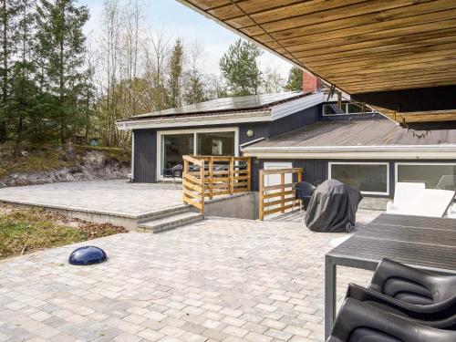 a patio of a house with a table and chairs at 12 person holiday home in Nexø in Snogebæk