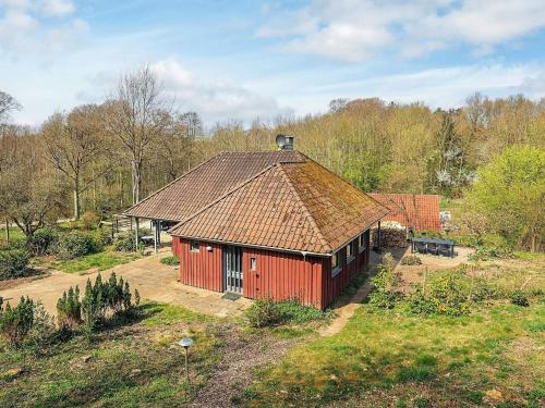 a red building with a roof in a field at 6 person holiday home in Asperup in Asperup