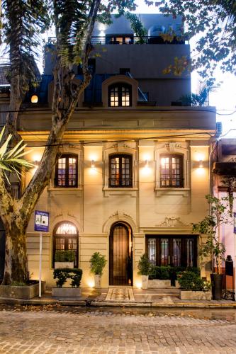 a building with a tree in front of it at Miravida Soho Hotel & Wine Bar in Buenos Aires