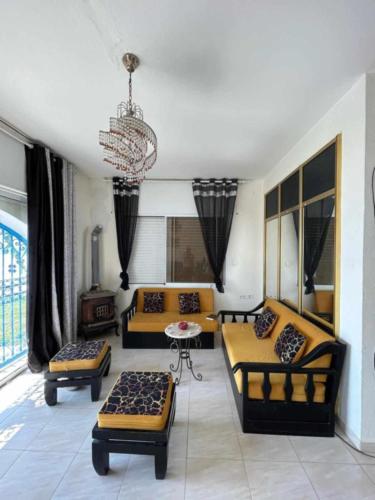 a living room with couches and a chandelier at Maison fatha in Kelibia