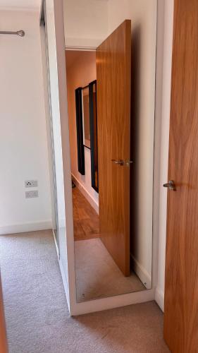 an open door in a room with a mirror at Valerie MMXXV in Luton