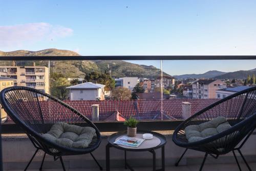 two chairs and a table on a balcony with a view at Central Rooftop Apartment in Trebinje