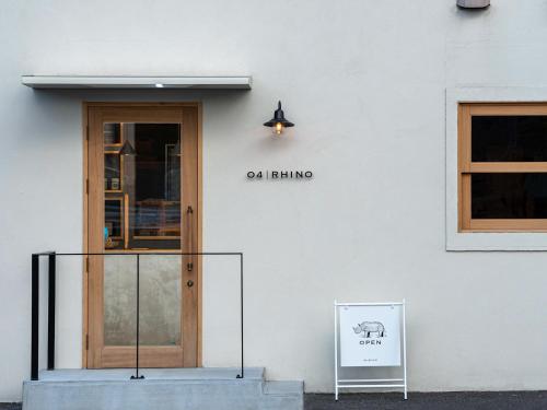a white building with a door and a sign on it at Business Hotel KG in Oita