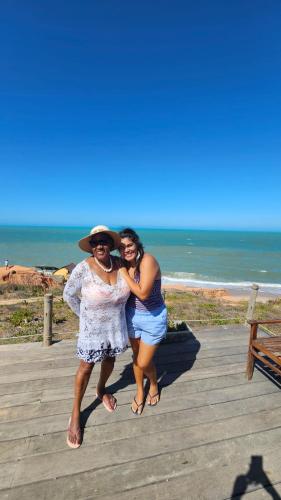 two women posing for a picture on the beach at Chales Da Mata in Fortim