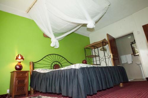 a bedroom with a bed and a green wall at Khweza Bed and Breakfast in Nairobi