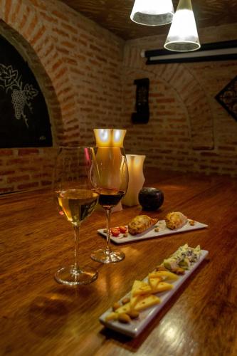 two glasses of wine and a plate of food on a table at Miravida Soho Hotel & Wine Bar in Buenos Aires