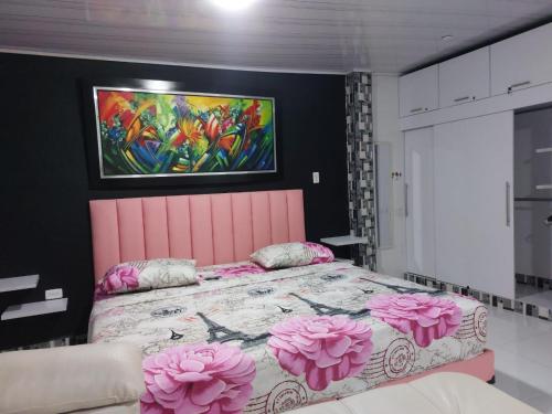 a bedroom with a pink bed with pink flowers on it at Posada Cocos Place in San Andrés