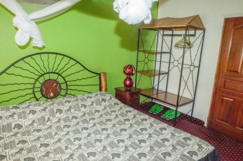 a bedroom with a bed and a green wall at Khweza Bed and Breakfast in Nairobi