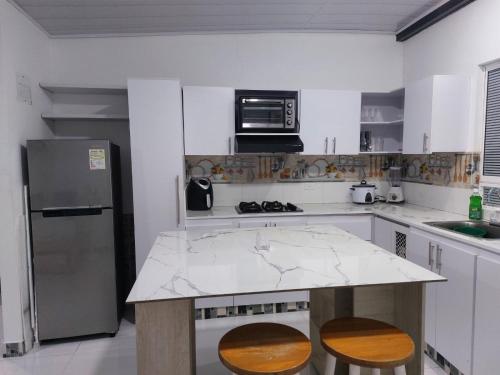 a kitchen with a marble counter and two chairs at Posada Cocos Place in San Andrés