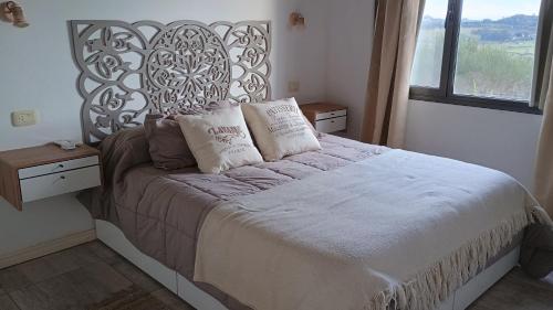 Un dormitorio con una cama grande con almohadas. en Cabaña La Resolana, en Tandil