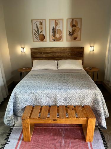 a bedroom with a bed and a wooden bench at Sattva Pousada in Pirenópolis