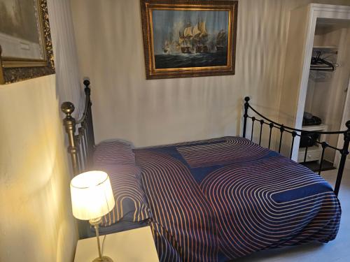 a bedroom with a bed with a striped blanket at 3-Bed Cottage - fast WiFi-Big Garden - Town Centre in Kirriemuir