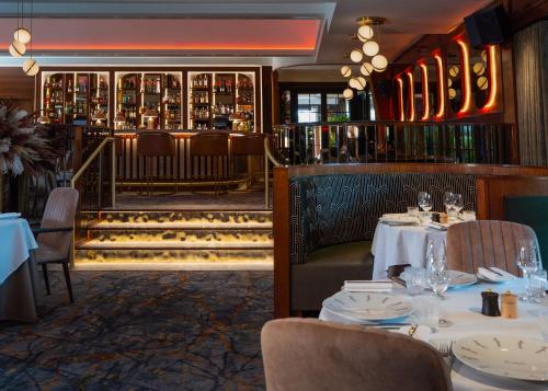 a restaurant with tables and chairs and a bar at Crossbasket Castle, Hotel & Restaurant in High Blantyre