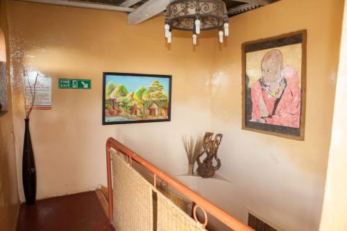 a hallway with paintings on the wall and a staircase at Khweza Bed and Breakfast in Nairobi