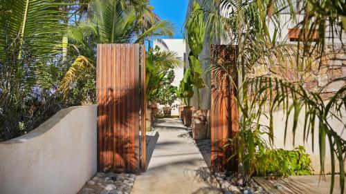 a walkway with palm trees and a fence at Beachfront Villa Punta Mita Litibu in Higuera Blanca