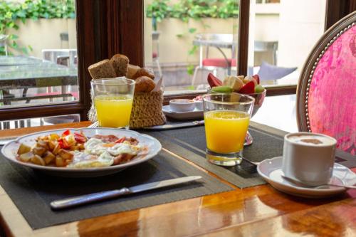 a table with a plate of breakfast food and orange juice at Miravida Soho Hotel & Wine Bar in Buenos Aires
